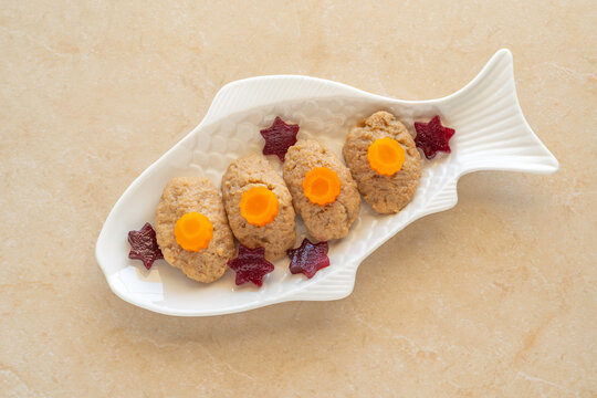 Jewish holiday Pesach or Passover food background with gefilte fish on ceramic platter.