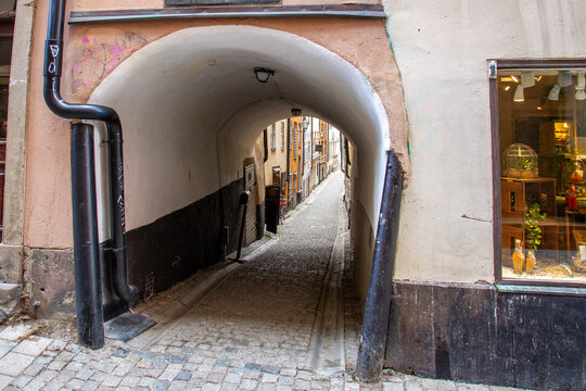 An authentic archway leading to the historic Stora Hoparegrand cobblestone street in Gamla Stan, Stockholm. Perfect for European travel, historic architecture, and Scandinavian tourism themes.
