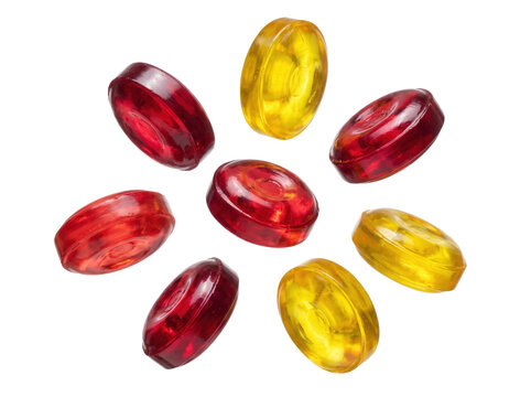 Red and yellow hard candies arranged in a circular pattern on black background, glossy fruit-flavored lozenges for cough drop packaging and confectionery product marketing.