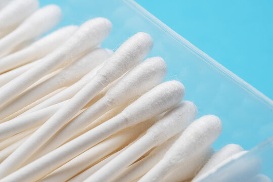 Cotton sticks or cotton swabs in a transparent box on a blue background