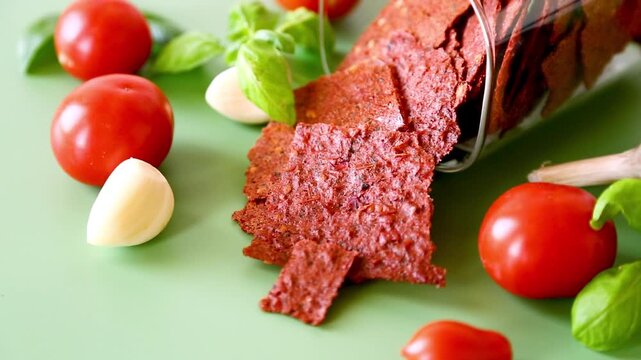 Natural tomato pastila with fresh ingredients on green background