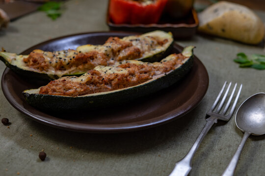 Baked stuffed peppers and zucchini with minced meat, cheese and herbs on rustic plate