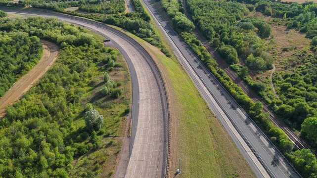 Aerial View of a Vehicle Testing Facility With a Car Driving on a Curved Track During the Daytime