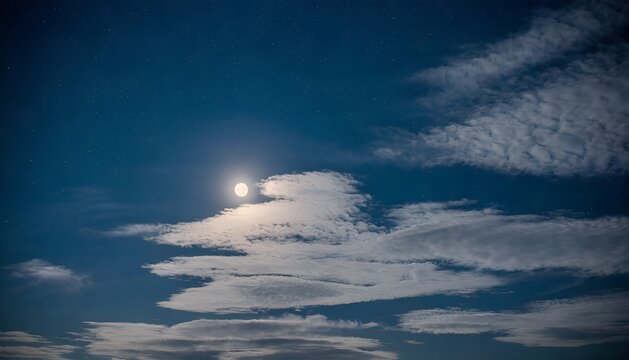 Nighttime sky with bright full moon and scattered clouds in natural light