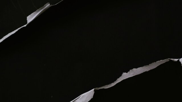 Abstract background featuring torn black paper edges revealing a dark void underneath.