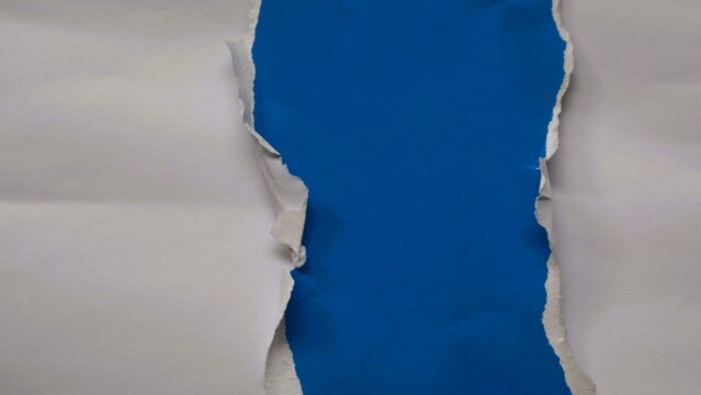 White paper torn in the middle revealing a solid blue background underneath.