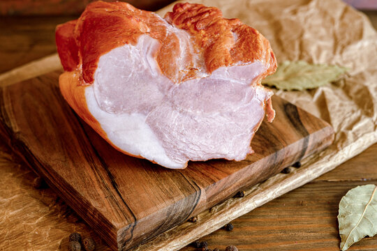 Traditional smoked pork ham sliced on wooden board, artisan charcuterie