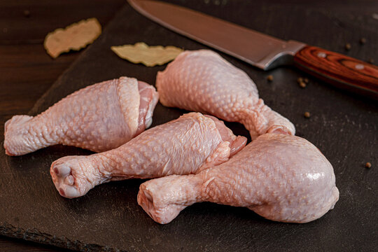 Raw chicken meat cuts including wings, breast fillet and drumsticks on cutting board