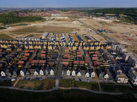 New housing development on a large construction site near Dartford in Kent, UK. Aerial view above newly built residential houses and empty land in ex quarry site for more houses to be build. 