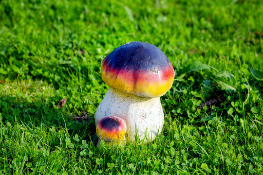 Garden figure of a boletus mushroom on a background of green grass. Flora plants flowers.