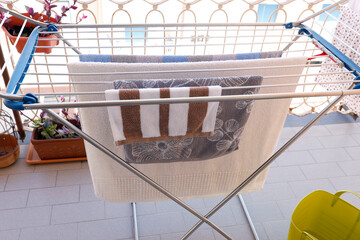 Drying clothes on balcony rack. Sustainable lifestyle choices at home. Eco friendly daily domestic...