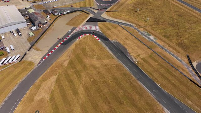 Racing Car Speeds Through the Sharp Turn at the Silverstone Circuit on a Sunny Summer Afternoon