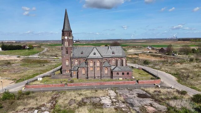 st albanus leonhardus church spire rises above demolished manheim alt village brick facade gothic arched windows cleared empty plots surround kerpen germany lignite mine excavator distant horizon