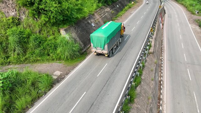 Drone Shot Following Freight Dump Truck Navigating Hill Road on Himachal Highway