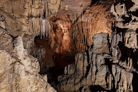 Mineral deposits and thick formations covering vertical rock walls inside a cave, Pyrenees, France