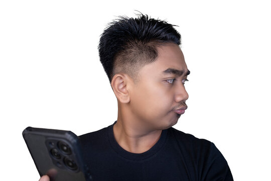 Skeptical and dismissive Indonesian man in a black t-shirt looking away while holding a smartphone with a side-glance expression against a white background.