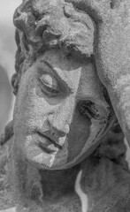 Fototapeta premium Close-up of a sorrowful stone angel statue, symbolizing grief, mourning, loss and remembrance.