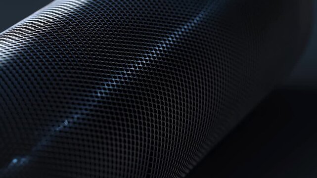 Black speaker mesh texture illuminated with cool edge light in dark room