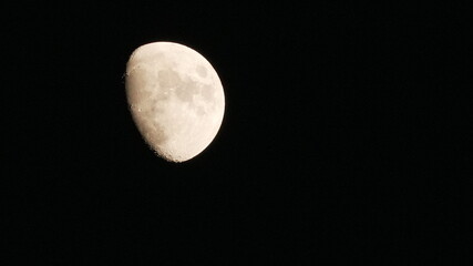 Detailed waxing gibbous moon with visible craters and surface texture isolated on black night sky © Silmiart