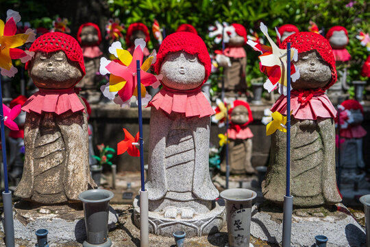 Simp&aacute;ticas estatuas jizo vestidas con sombreros y tapados. En Santuario Japones, en Kioto