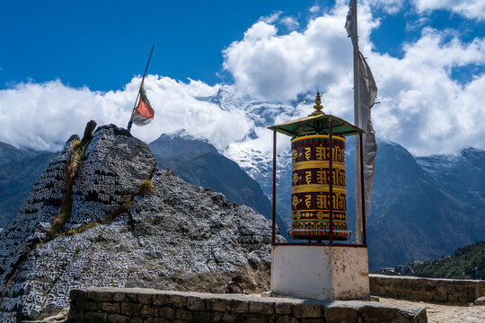 Inscripciones, banderas y rueda de plegarias budistas en la regi&oacute;n de los himalayas, en Nepal.	