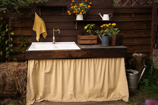 White sink with faucet and yellow towel hanging on the side in a rustic kitchen. interior design, hospitality, real estate. cozy home atmosphere, rustic charm, warm living space. kitchen decor, vintag