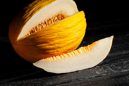 sliced casaba melon on black wood background