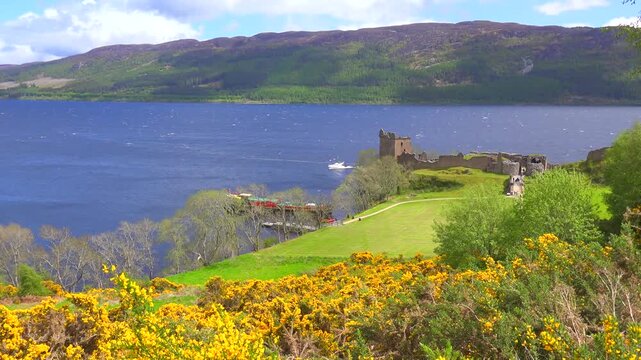 Stunning panoramic view of historic Urquhart castle ruins situated on banks of Loch Ness in Scottish Highlands.