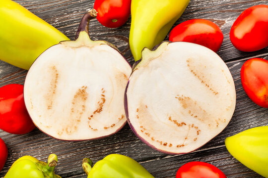sliced round purple eggplant on wood background