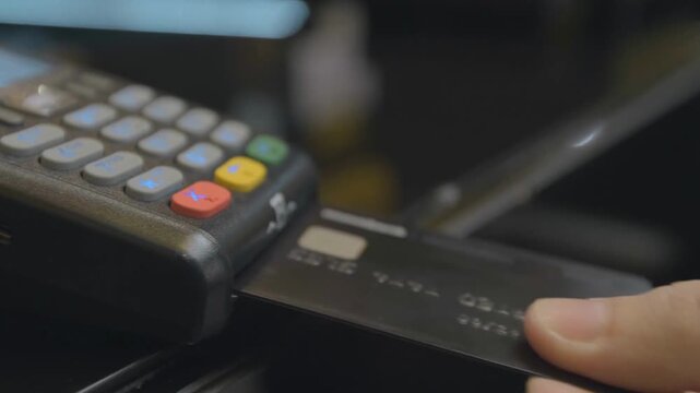 Man Paying With Credit Card Through POS Terminal in Store