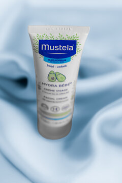 Lviv Ukraine - September 12, 2026: Mustela Hydra Bebe facial cream tube for baby skin care on blue silk fabric background
