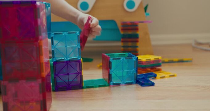 Child building a structure with magnetic tiles