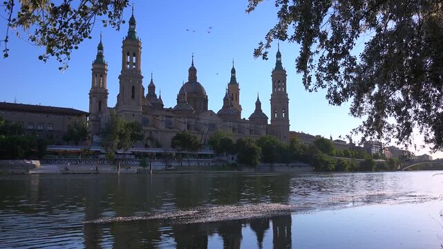 Stunning morning light illuminates the iconic basilica of our lady of the pillar across the ebro river in zaragoza spain.
