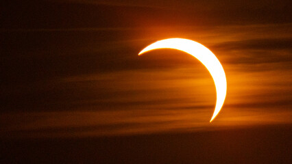 Partial solar eclipse on September 12, 2026, with the Moon visibly covering a significant portion of the Sun. The Sun appears as a bright orange crescent against a dark sky.  © coffeinlix 