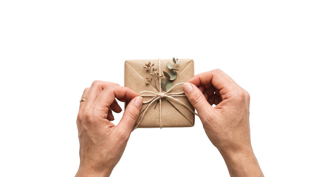 Rustic gift box wrapped in brown kraft paper, hands tying twine bow on eco-friendly package, minimalist present with dried eucalyptus