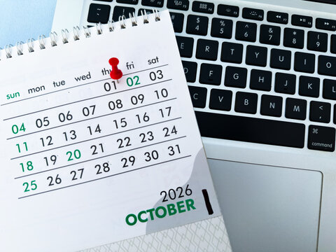 First October month 2026 desk calendar marked with red push pin