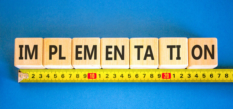 Implementation word symbol. Concept word Implementation on beautiful wooden blocks. Beautiful blue background. Beautiful yellow ruler. Business implementation word concept. Copy space.