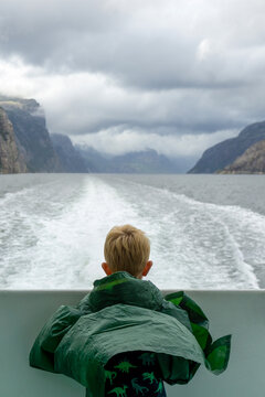 Young boy on boat observing Lysefjord Norway landscape