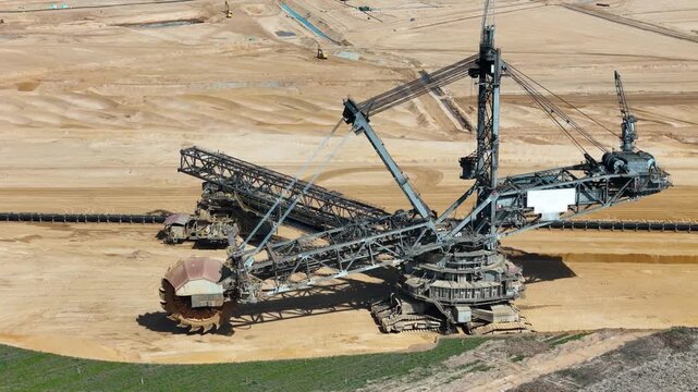 aerial orbit reveals bucket wheel excavator steel lattice framework conveyor arm crawler tracks anchor colossal machine open pit lignite mine kerpen germany surface mining drone footage