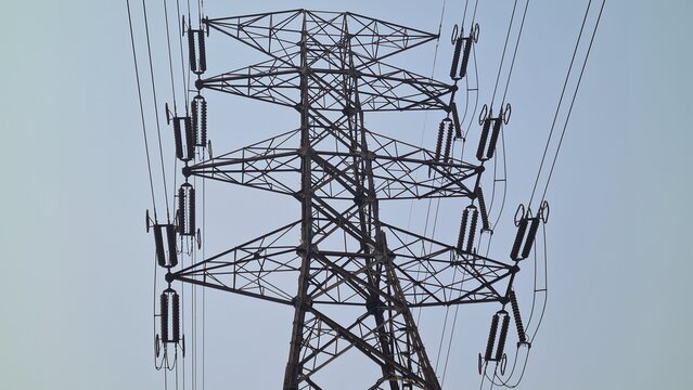 Imposing high-voltage electricity pylon with a complex array of power lines, signifying crucial energy infrastructure and the intricate network of modern power transmission