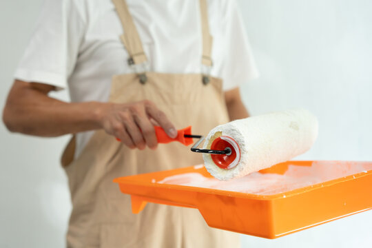 painter man, brush in hand for products to restore and paint the wall, indoor the building site of a house, wall during painting, renovation, painting, contractor, Architect, construction worker