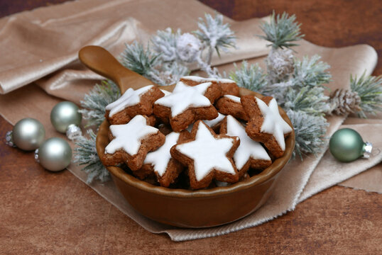 Classic cinnamon stars in a rustic bowl, with Christmas decorations and baubles.