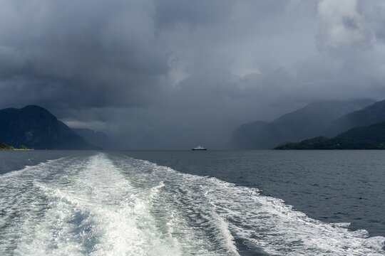 Ferry traveling H&oslash;gsfjord Norway under storm clouds