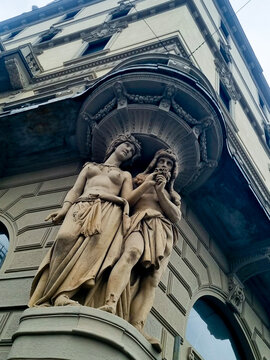 classical stone statues on an ornate historic building facade