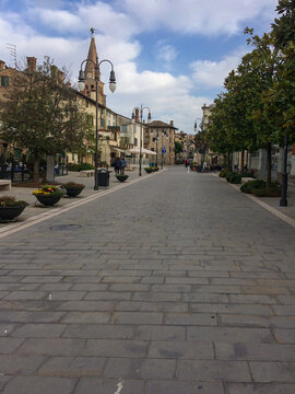 Paved pedestrian street lined with flowers and lampposts l