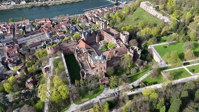 aerial orbit circles heidelberg castle courtyard red sandstone walls towers overlook old town neckar river old bridge forested hillside park grounds surround historic ruins germany heritage site