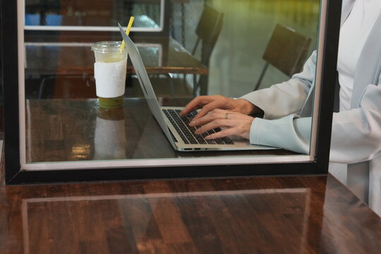 Hand businesswoman are sitting and working on their smartphones and laptops in a co-working caf&eacute;.
