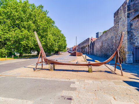 A view past a replica keel of a 14th century medieval cargo boat displayed along the historic Southampton Town Walls on Western Esplanade in Southampton, England, in summertime