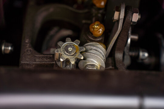 Close-up of greased worm gear drive and pinion wheel mechanism inside industrial machinery.