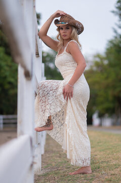 Young woman posing barefoot in country style dress